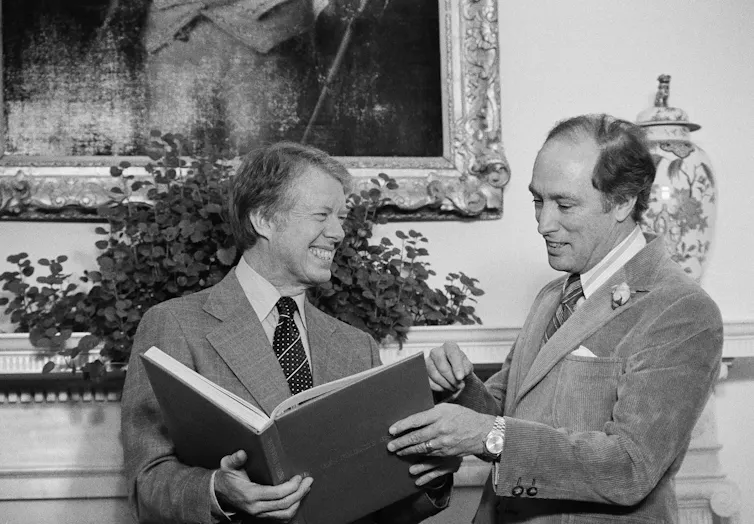 Two men hold a book