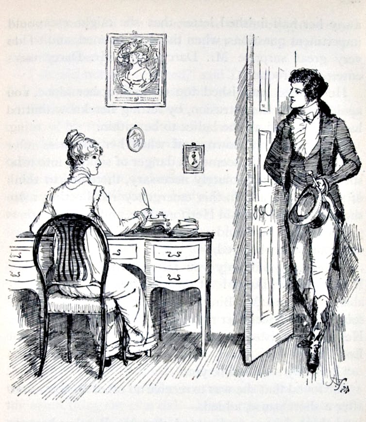A woman writes while sitting at a desk, while a man walks through he door and sees her.