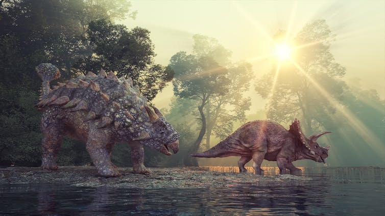 Two plant-eating dinosaurs pause at a watering hole.