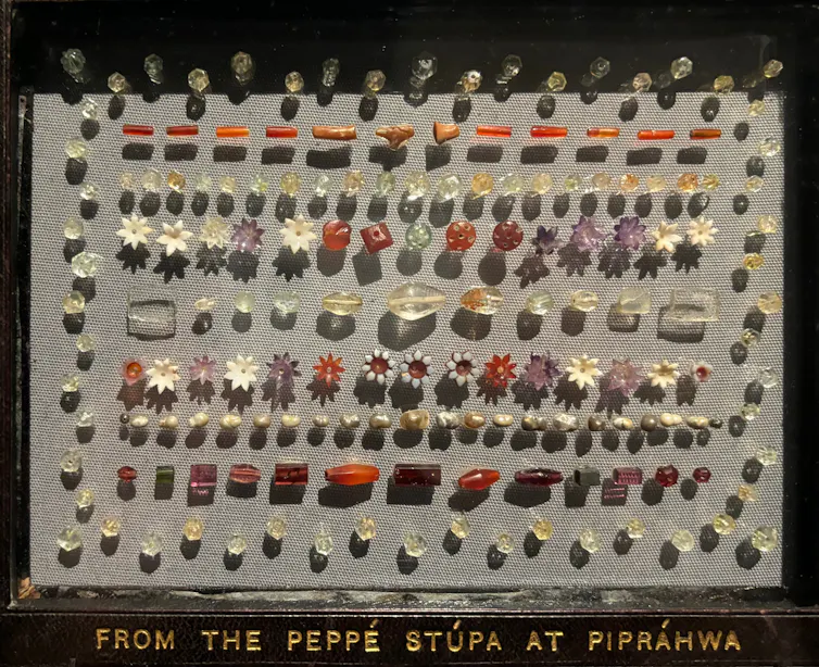 A set of gems lined up on a piece of beige material.