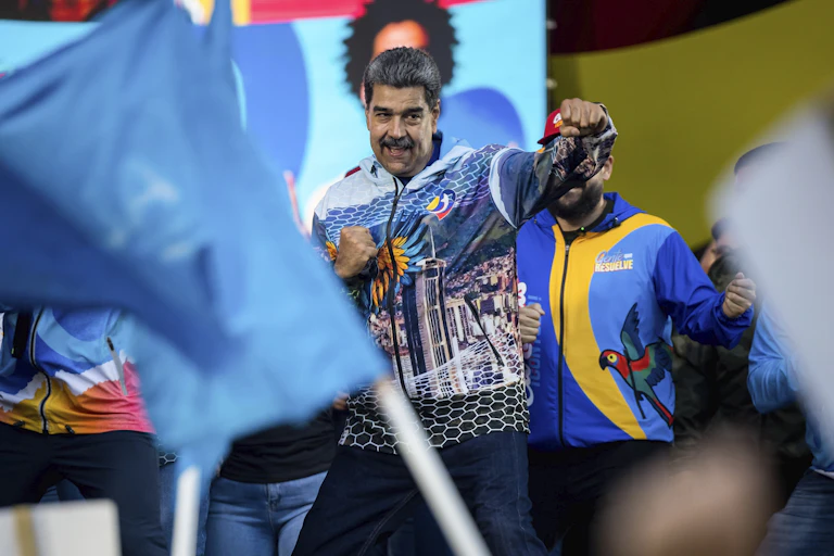 Maduro punches the air as he addresses a crowd.