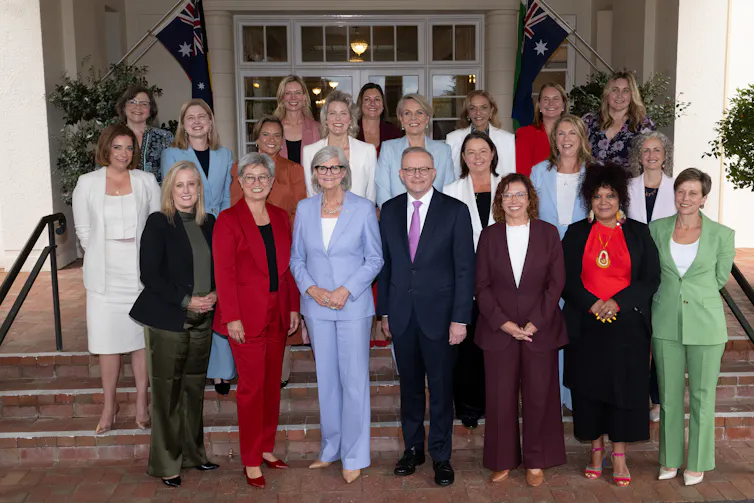 Anthony Albanese stands with the female members of his cabinet, smiling