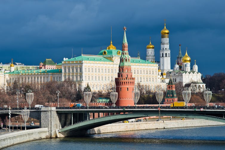 wintry shot of the kremlin in moscow with river and bridge in the foreground.