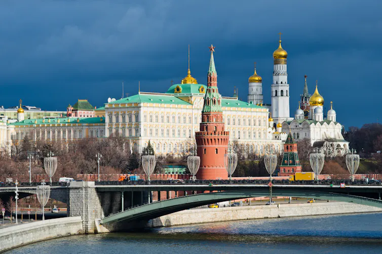 wintry shot of the kremlin in moscow with river and bridge in the foreground.