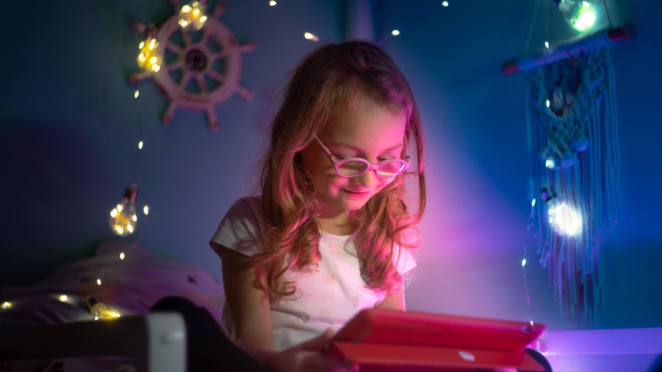 Niña viendo una pantalla en su habitación
