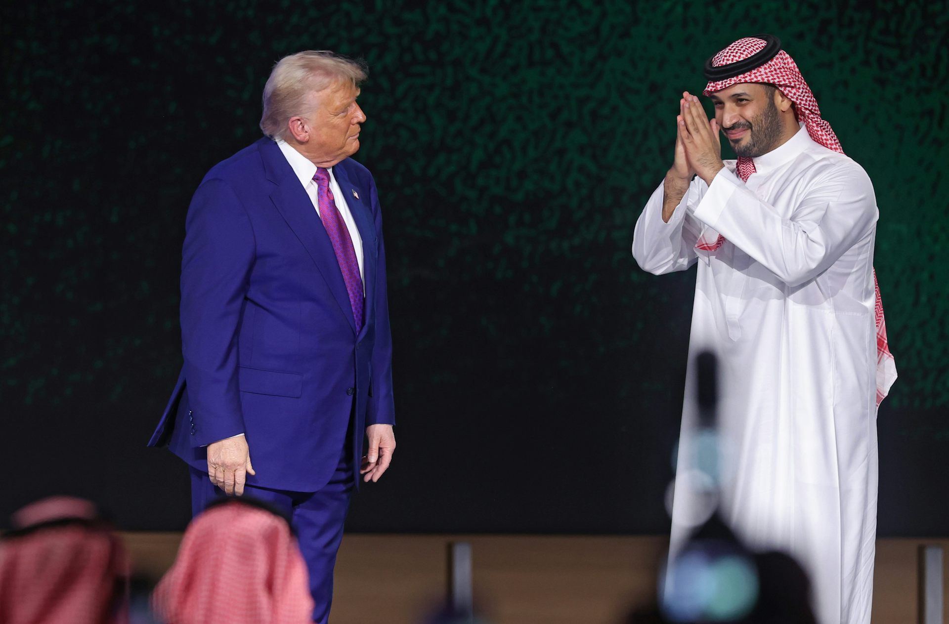Mohammed bin Salman faces Donald Trump with his hands in the prayer position.