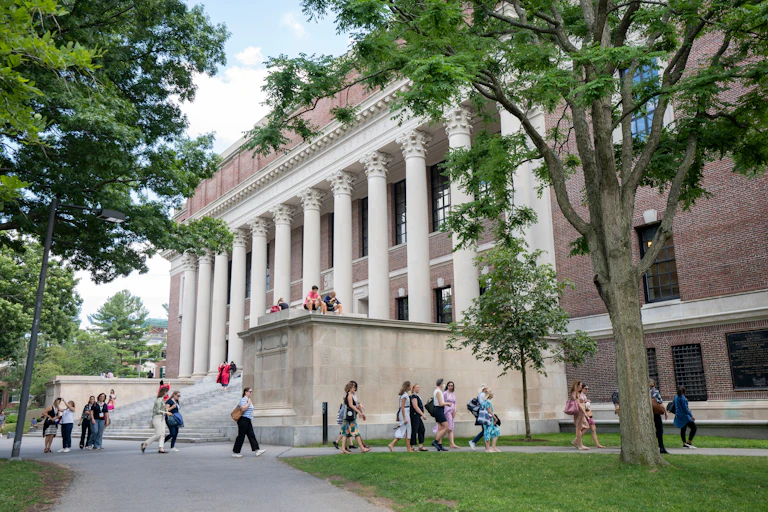 Estudiantes junto a un gran edificio con columnas