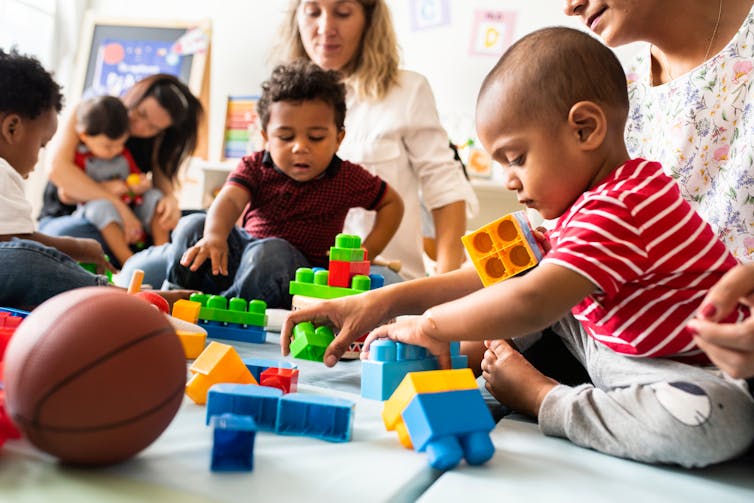 Padres y niños pequeños en el patio de recreo