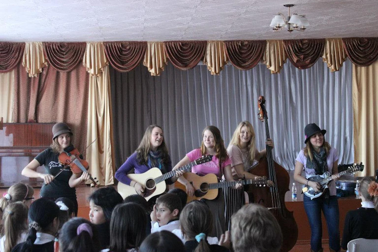 A group of musicians standing on stage, performing.