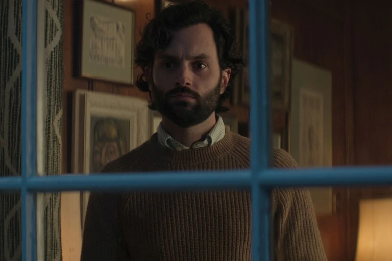 Hombre con barba asomándose a la ventana