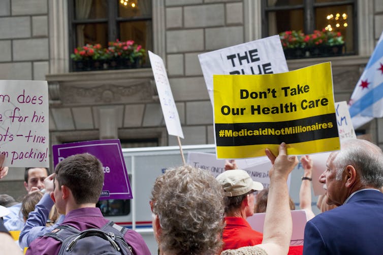 People holding signs at a protest in support of Medicaid