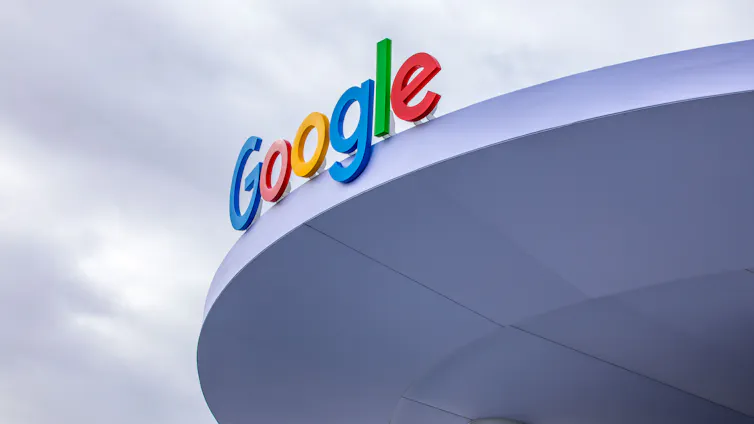 A blue, red, yellow and green Google sign on a building roof.
