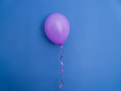 A blown-up purple balloon on a blue background.