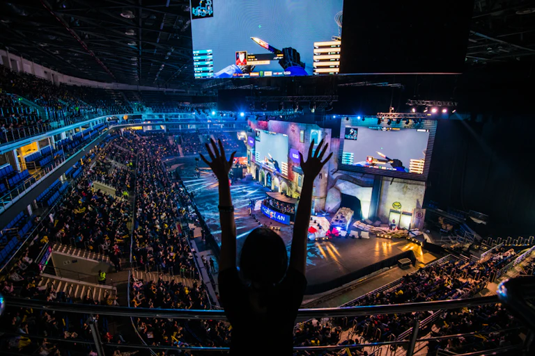 Fans cheer inside a stadium during an esports tournament.
