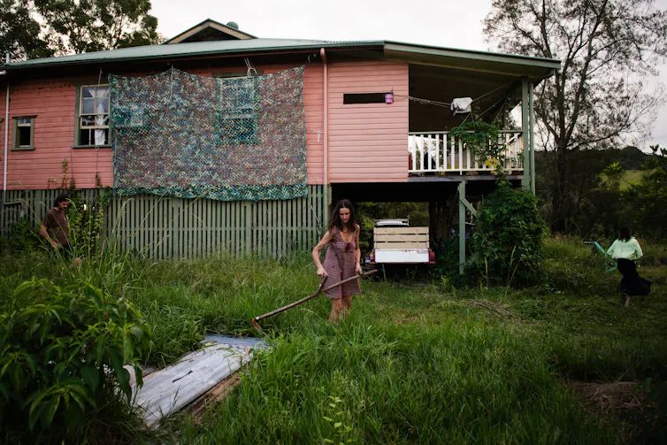 People in front of a flood damaged house in Lismore, NSW
