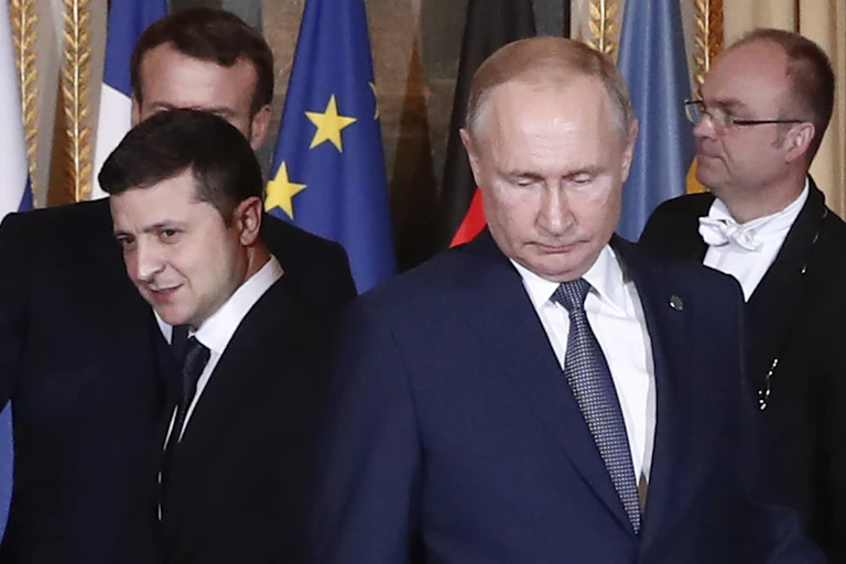 Two men in suits look downward.