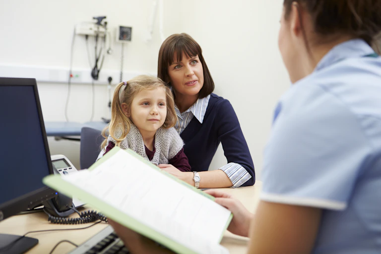 Mother and child talk to a GP