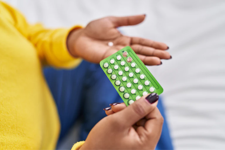 A woman holds a pack of birth control pills in her hands.