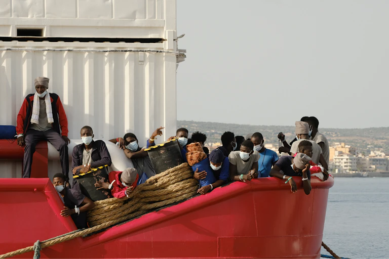 Un barco rojo con muchas personas dentro esperando.