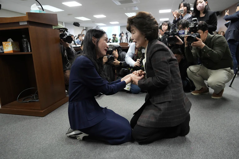 Truth and Reconciliation Commission Chairperson Park Sun Young, right, kneels next to adoptee Yooree Kim during a press conference in Seoul, South Korea