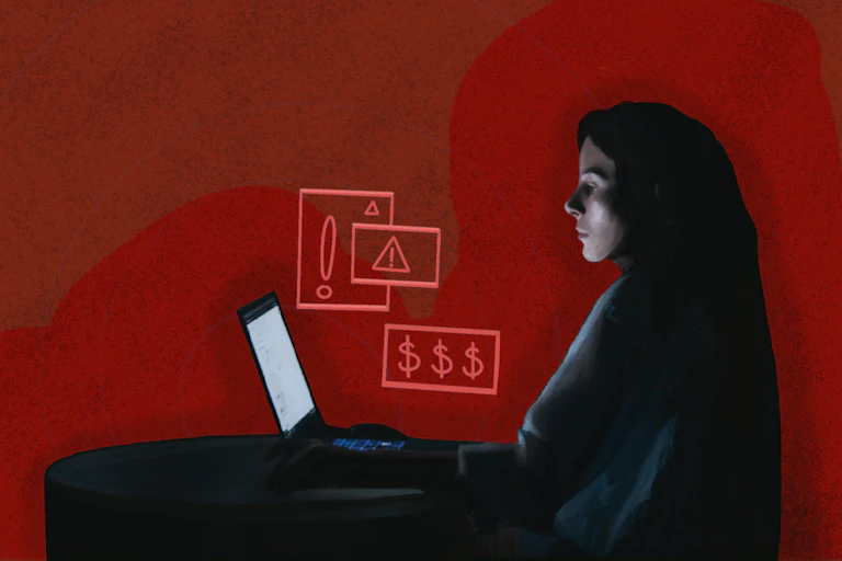a woman sits at a laptop against a red background