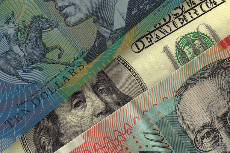 Portrait of Benjamin Franklin on US currency seen from underneath Australian dollar bills