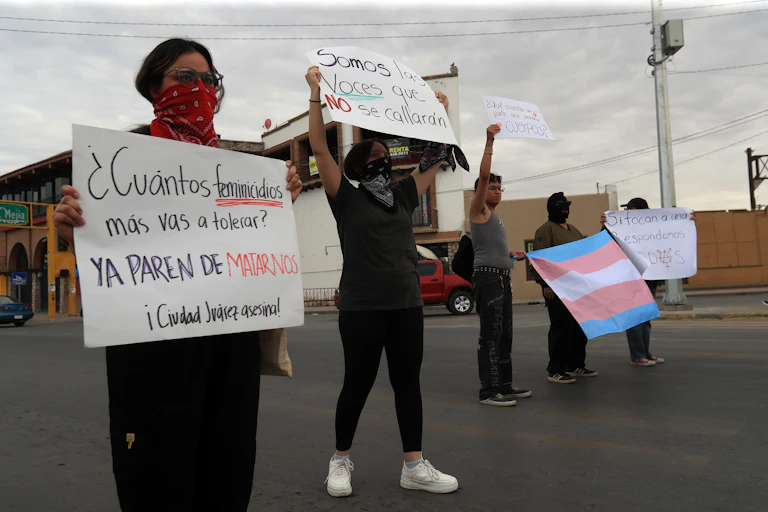 Several people holding placards in protest over a wave of femicides in Ciudad Juárez.