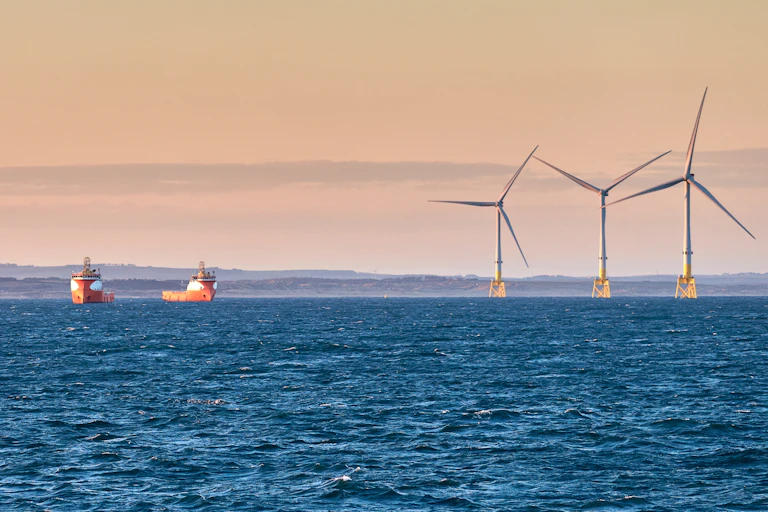 des bateaux et des éoliennes en mer