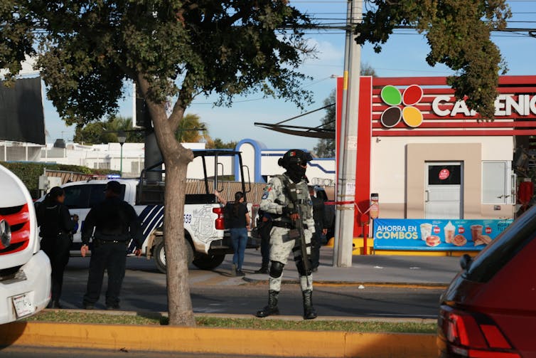 A member of Mexico's national guard at the site of a cartel shooting.