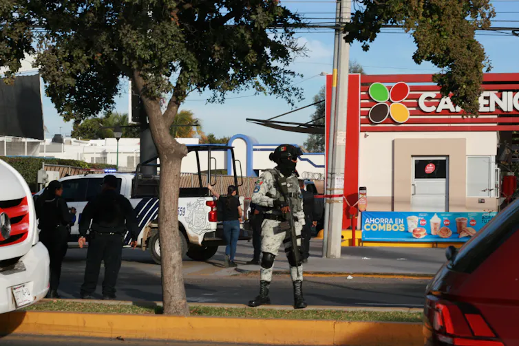A member of Mexico's national guard at the site of a cartel shooting.