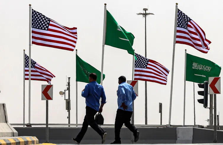 A street decorated with the flags of Saudi Arabia and the US.