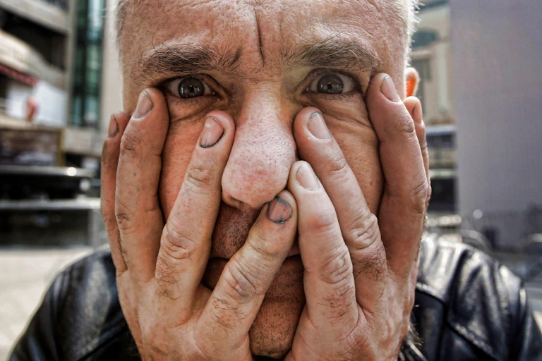 Close-up of artist Damien Hirst with his hands covering his face