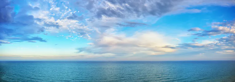 ocean surface with clouds in the sky