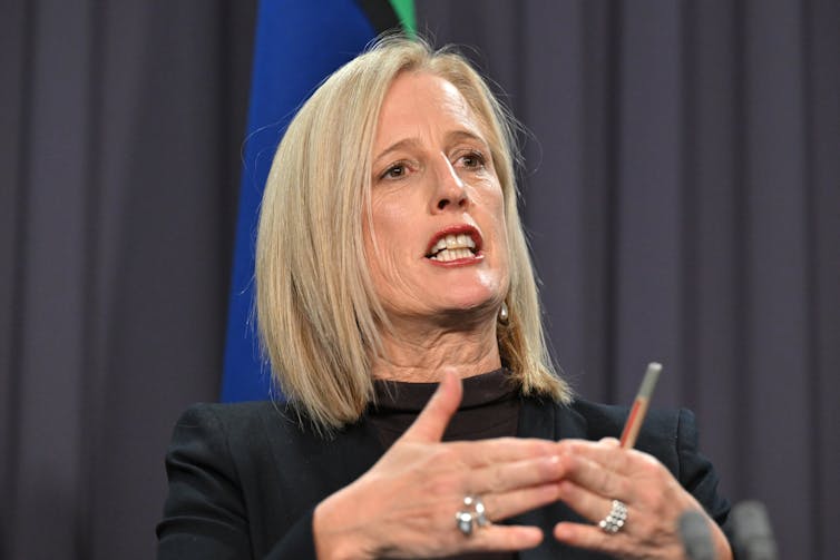 Minister for the Public Service Katy Gallagher in a black blouse against navy blue curtains