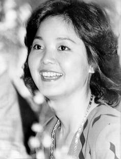 Black and white headshot of smiling young woman.