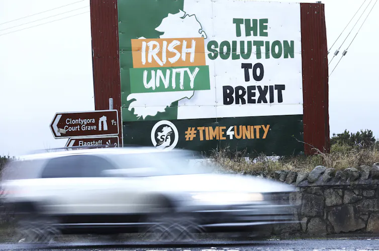 A roadside billboard says 'Irish Unity: The Solution to Brexit' as a car drives past.