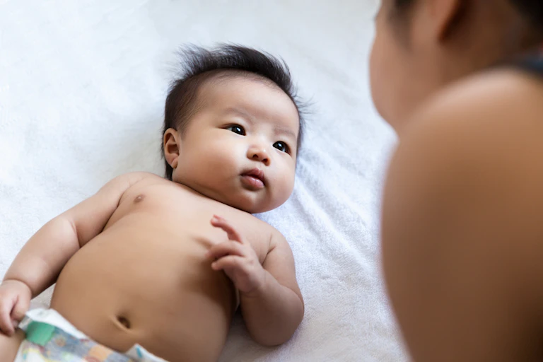 Um bebê observa o rosto da mãe enquanto ela fala.