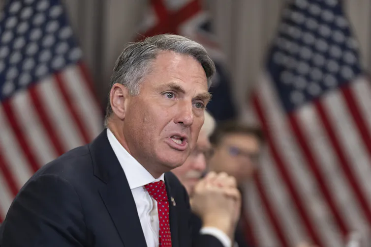 Richard Marles answers a question in front of a US flag.