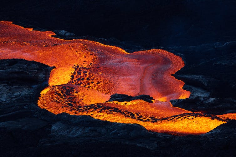 Photo of bright red lava on a black background.