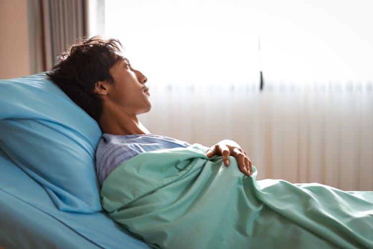 Man lays in hospital bed