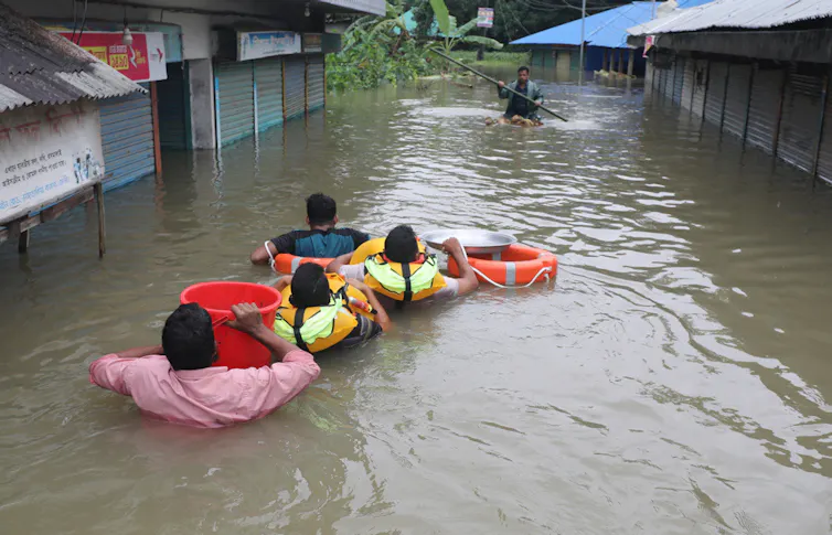 A family wades through chest-deep water.