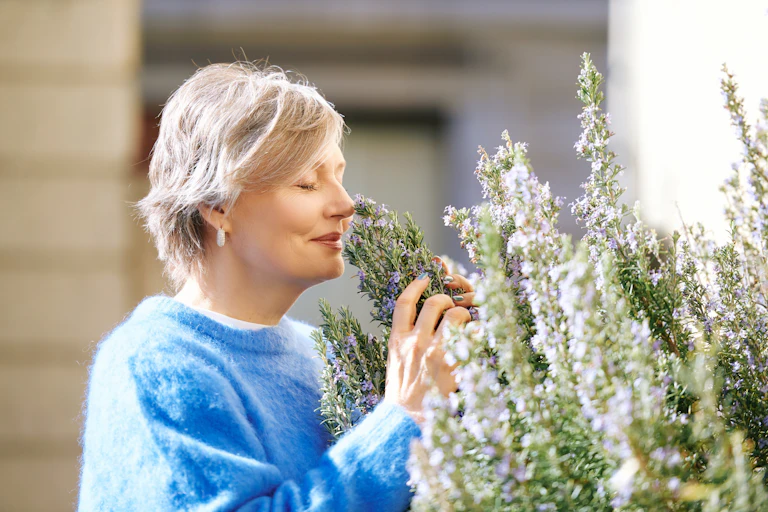 Woman smelling rosemary herb