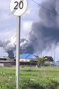 Plumes of smoke above an air base in a photograph taken from a distance.