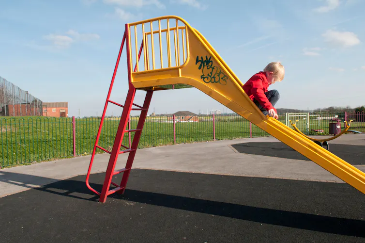 boy slides down slide