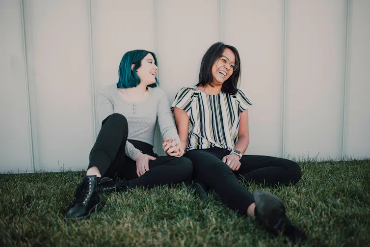 Two women holding hands and smiling
