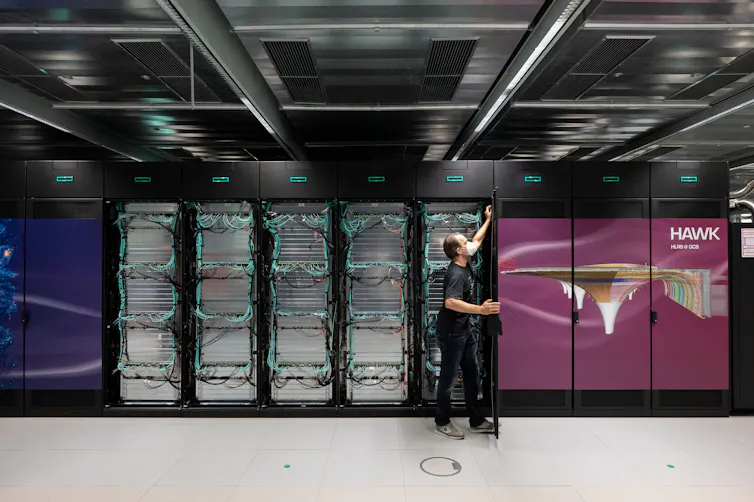 Photo of a man opening a rack of computer servers.