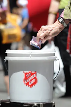 Person putting a donation in a Salvation Army bucket