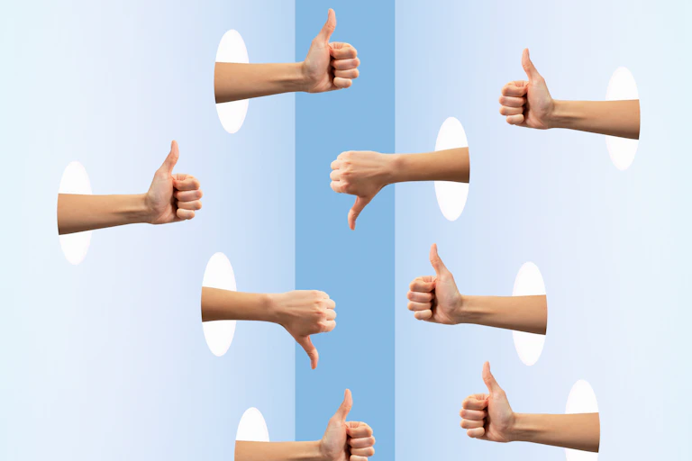 forearms reach out with thumbs-up or thumbs down-gestures against a blue background