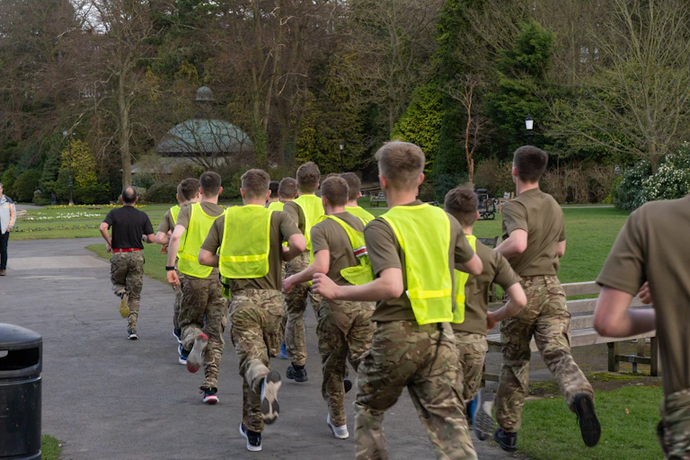 Group of men in hi-vis and camouflage running