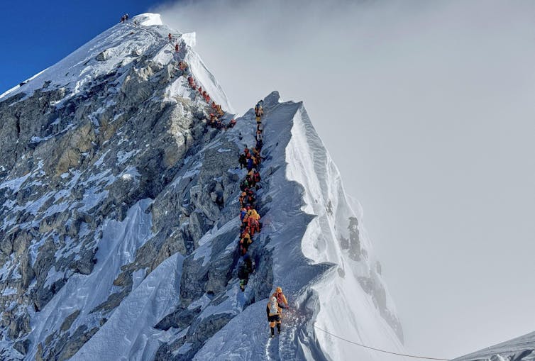 Mountaineers queue up to reach the summit of Everest.